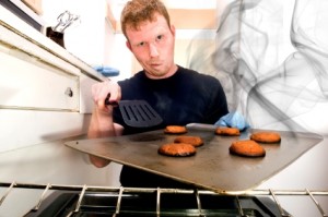 This image shows a guy with a pan of smoking cookies.